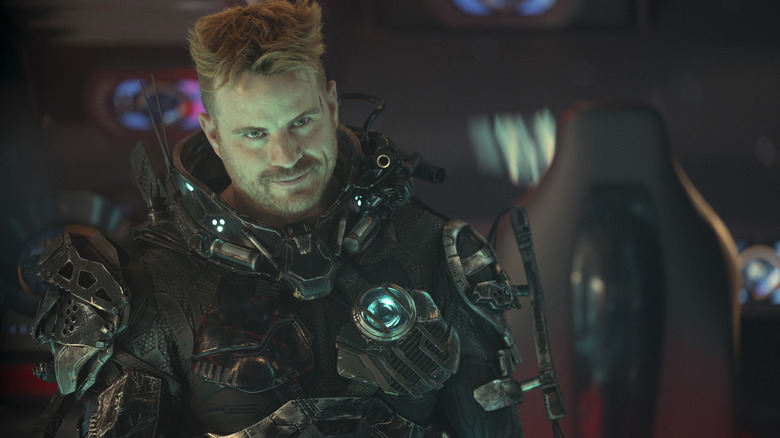 Rob Kazinsky sebagai Zeph mengenakan jas mech -nya dan senyum di Star Trek: Bagian 31