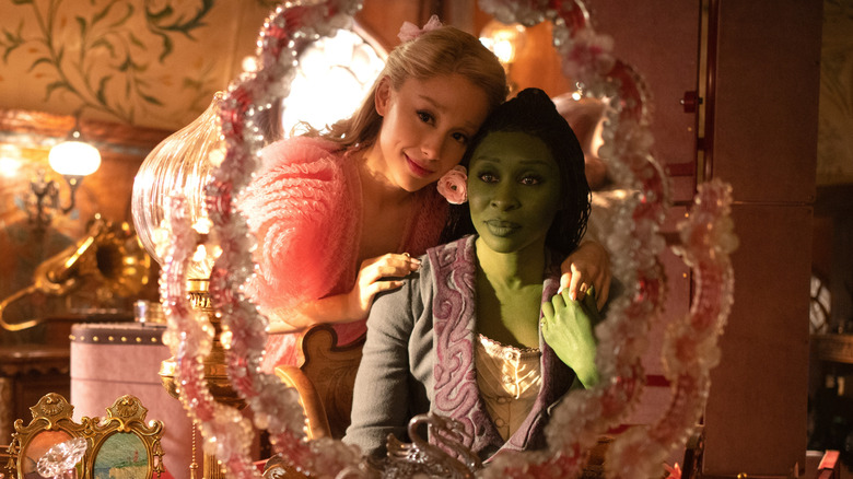 Glinda dan Elphaba melihat ke cermin merah muda di Wicked