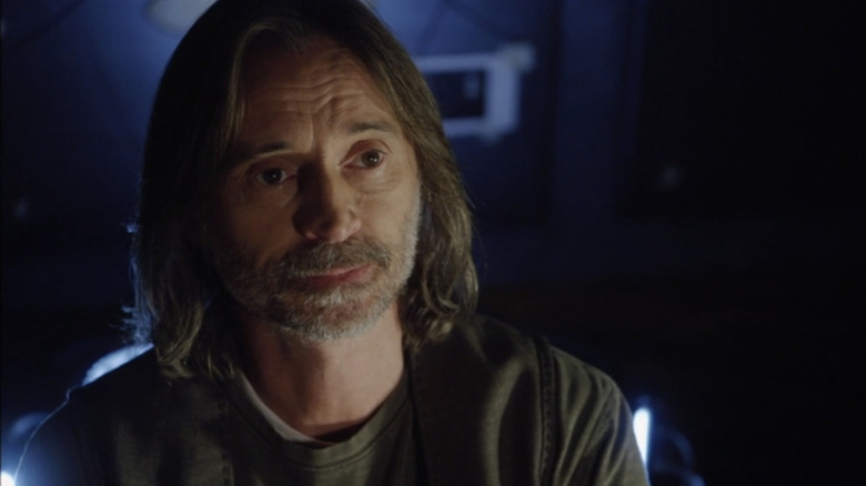 Robert Carlyle's Nicholas Rush melihat ke seberang bingkai di Stargate Universe