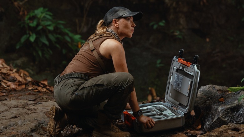 Scarlett Johansson sebagai Zora Bennett berjongkok di atas tas kerja di Jurassic World Rebirth