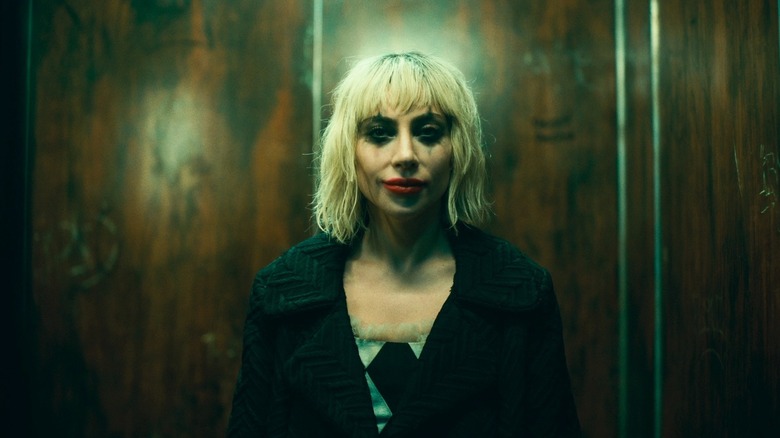 Harley Quinn dari Lady Gaga mengenakan riasan dan tersenyum di Joker: Folie A Deux