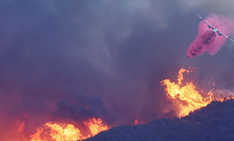 Sebuah pesawat pemadam kebakaran menjatuhkan penghambat api merah muda Phos-Chek di Pacific Palisades pada 7 Januari