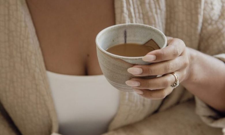 Wanita menulis jurnal dan minum kopi.