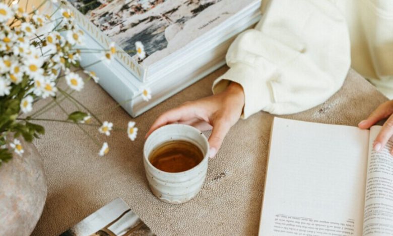 Wanita membaca buku meja kopi tentang cara melakukan edit hidup.