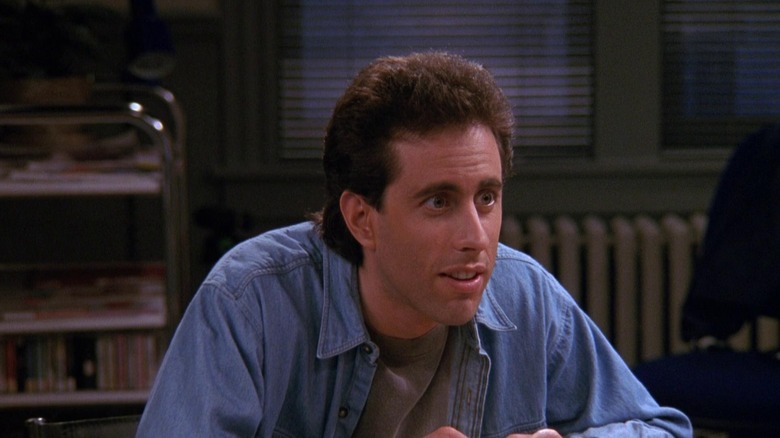 Jerry Seinfeld dengan kemeja biru di apartemennya.