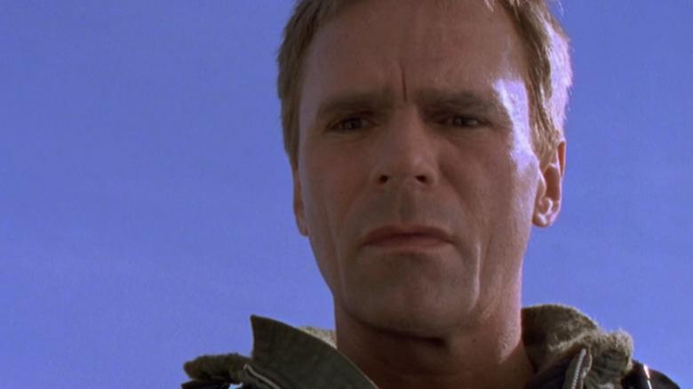 Jack O'Neill dari Richard Dean Anderson melihat ke bawah dengan langit biru jernih di latar belakang di Stargate SG-1