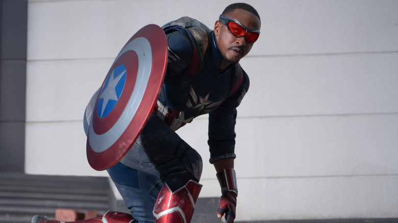 Anthony Mackie As Sam Wilson memegang perisai Cap dalam jongkok di Captain America: Brave New World