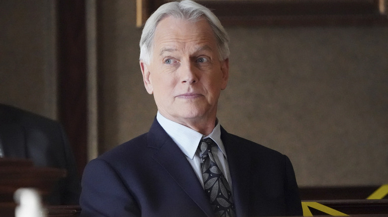 Gibbs terlihat di sebelah kanannya dengan senyum halus di NCIS