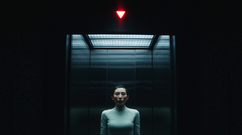 Gemma Dichen Lachman sebagai Ms. Casey Innie berdiri di lift di Severance