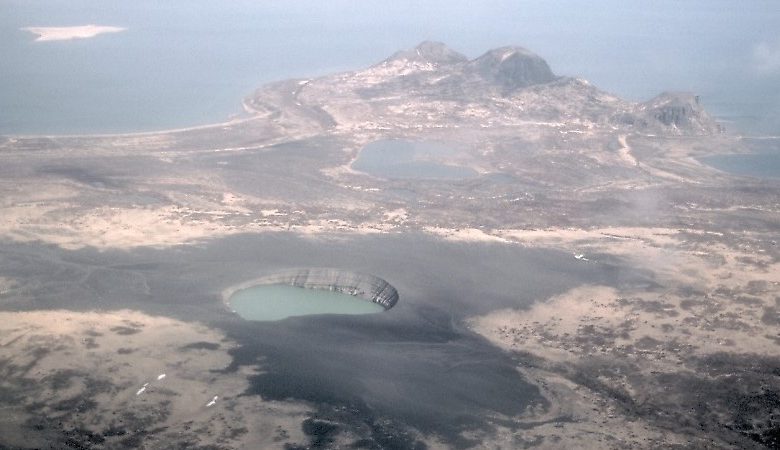 Pemandangan Ukinrek Maars di Alaska. Kami melihat kawah diisi dengan air dan danau di kejauhan.