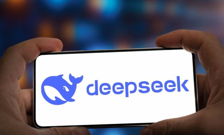 Tangan seseorang memegang telepon yang menampilkan logo Deepseek.