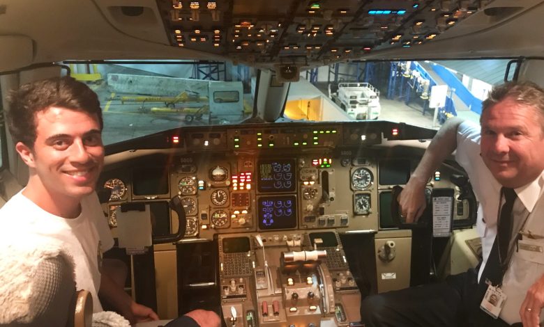 Nick ditampilkan di kokpit pesawat dengan pilot. Mereka berdua tersenyum dan melihat ke arah kamera.