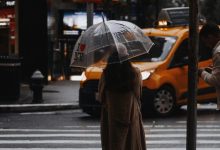 Wanita dengan payung berdiri di jalan New York