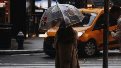 Wanita dengan payung berdiri di jalan New York