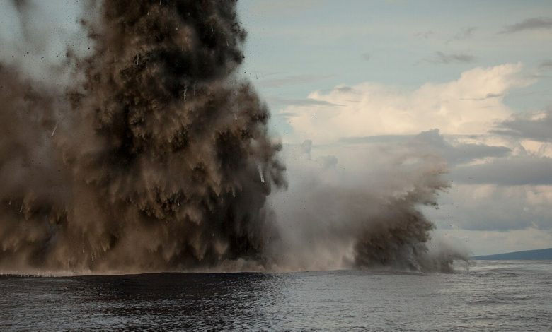 Gumpalan raksasa asap hitam dan air meletus dari permukaan laut