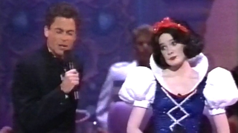 Rob Lowe dan seorang aktris berpakaian seperti Snow White Holding Microphone dan bernyanyi di atas panggung Oscar 1989