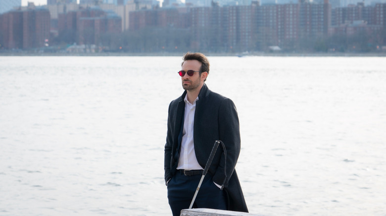 Charlie Cox sebagai Matt Murdock berdiri di tepi sungai di Daredevil: Born Again