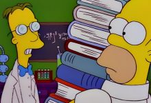 Profesor Frink berbicara dengan Homer saat ia memegang buku -buku di depan papan tulis dan peralatan lab di Simpsons.