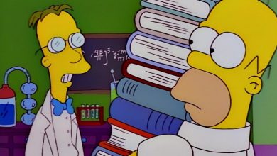 Profesor Frink berbicara dengan Homer saat ia memegang buku -buku di depan papan tulis dan peralatan lab di Simpsons.