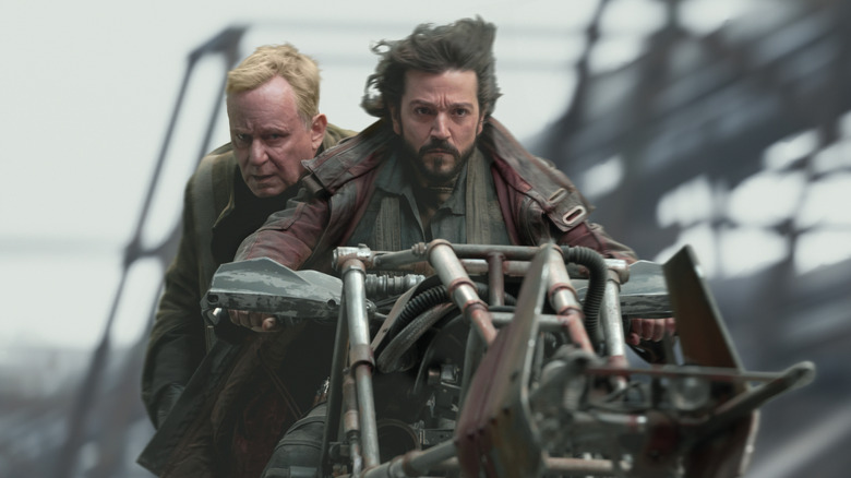 Luthen dan Cassian mengendarai sepeda speeder di Ferrix di Andor