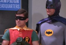 Robin dan Batman, dari serial TV Batman 1966, berdiri di depan markas kampanye Batman.