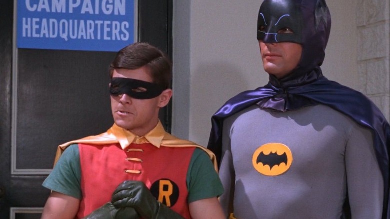 Robin dan Batman, dari serial TV Batman 1966, berdiri di depan markas kampanye Batman.