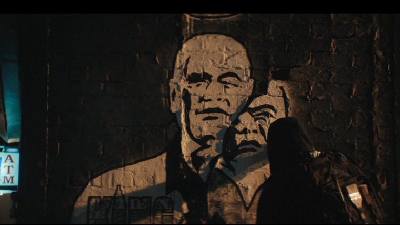 Semprotan sosok berkerudung melukis grafiti kingpin (Vincent d'Onofrio) di Daredevil: Born Again