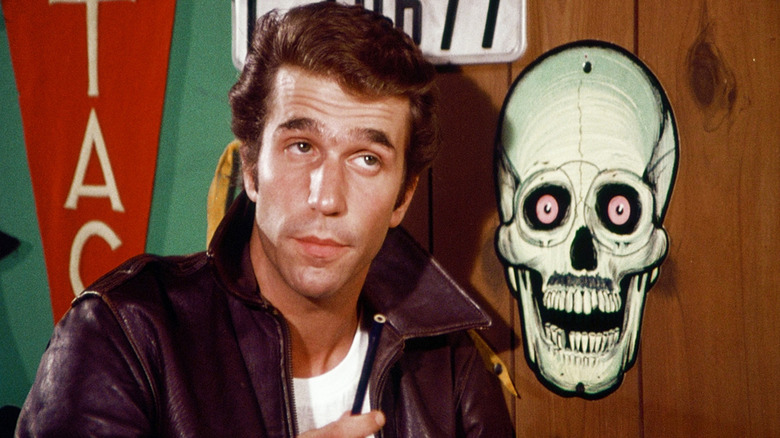 Fonzie berdiri di sebelah logo tengkorak di hari -hari bahagia