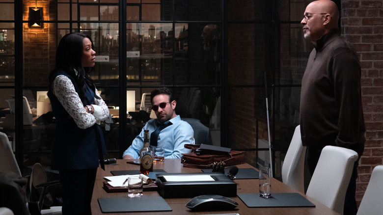 Niki M. James sebagai Kirsten McDuffie, Charlie Cox sebagai Matt Murdock, dan Clark Johnson sebagai Cherry berkumpul di sekitar meja konferensi di Daredevil: Born Again