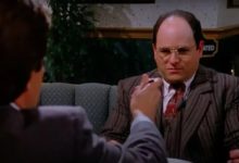 George, duduk di meja, menolak untuk makan makanan yang ditawarkan kepadanya. Adegan dari Seinfeld.