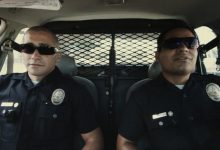 Brian Taylor dari Jake Gyllenhaal dan Michael Peña Mike Zavala duduk berdampingan di mobil polisi mereka di akhir Watch