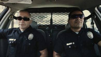 Brian Taylor dari Jake Gyllenhaal dan Michael Peña Mike Zavala duduk berdampingan di mobil polisi mereka di akhir Watch