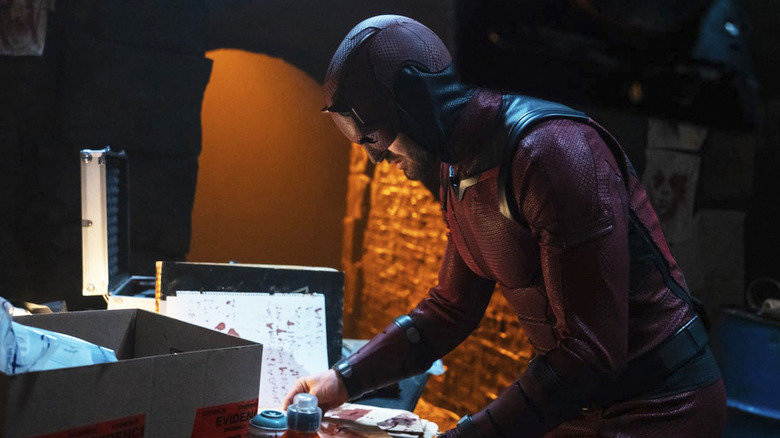 Matt Murdock dari Charlie Cox mencari melalui beberapa kertas dengan setelan pemberani di Daredevil: Born Again