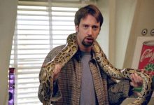 Tom Green sebagai Barry memegang ular dalam perjalanan