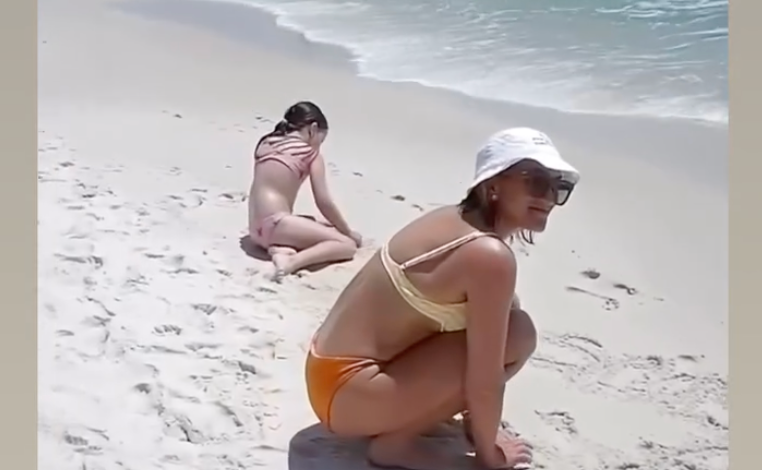 Jamie Lynn Spears menulis di atas pasir.