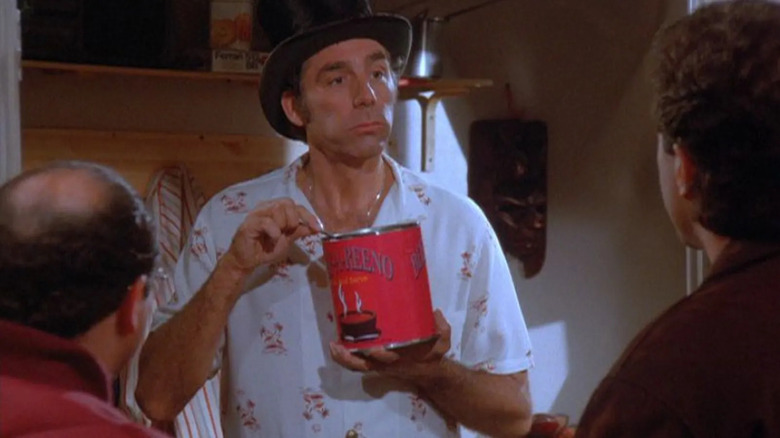 Kramer dengan topi top, makan sekaleng besar daging sapi-a-reeno, berdiri di depan Jerry dan George. Dari episode Seinfeld.