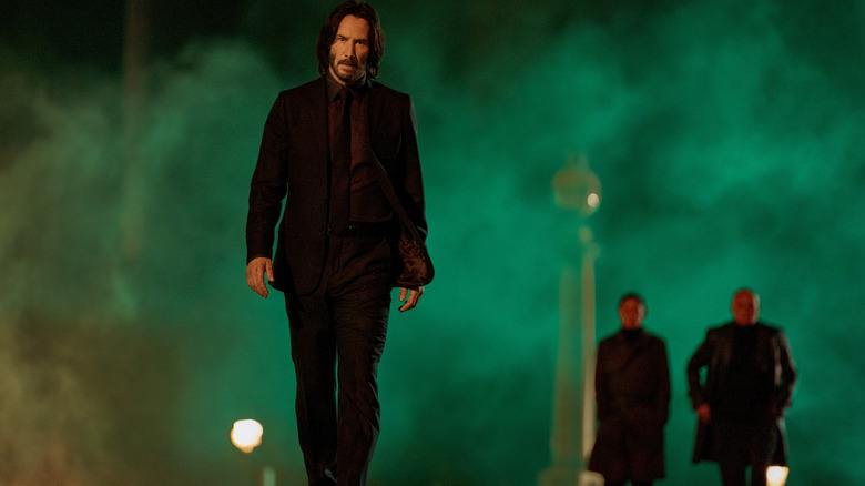 Keanu Reeves As John Wick berjalan menyusuri jalan berkabut di John Wick: Bab 4