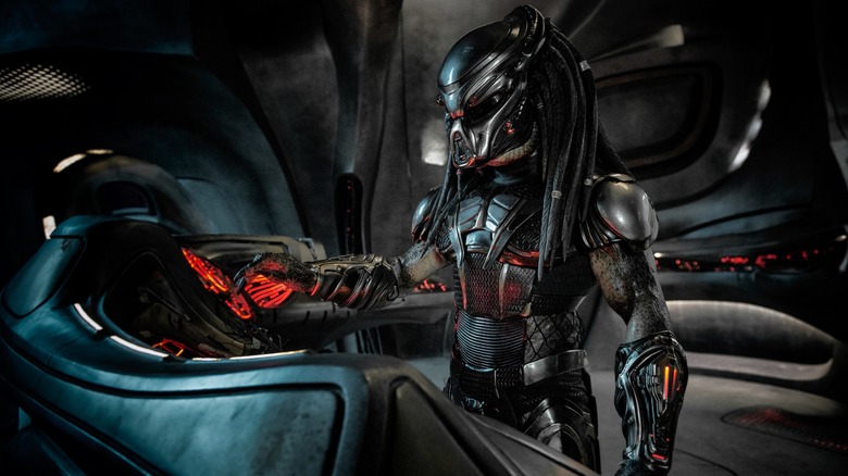 Predator berdiri di panel kontrol pesawat ruang angkasa di Predator (2018)