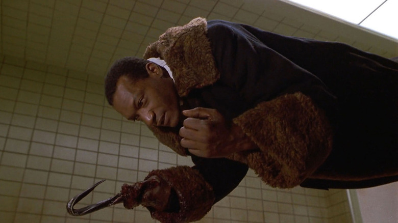 Candyman, mengambang secara horizontal di udara di kamar rumah sakit, tangan kaitnya terangkat. Adegan dari candyman.