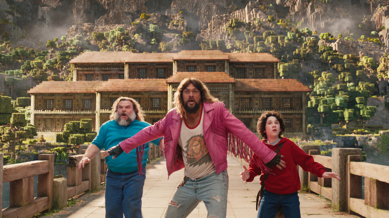 Jack Black sebagai Steve, Jason Momoa sebagai Garrett, dan Sebastien Hansen sebagai Henry berlari melintasi jembatan dalam film Minecraft