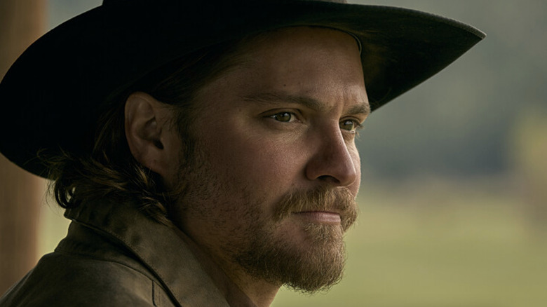 Luke Grimes's Kayce Dutton melihat ke kejauhan di Yellowstone