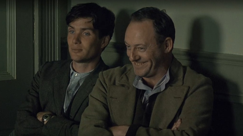 Damien O'Donovan (Cillian Murphy) dan Dan (Liam Cunningham) duduk bersama di angin yang mengguncang gandum.