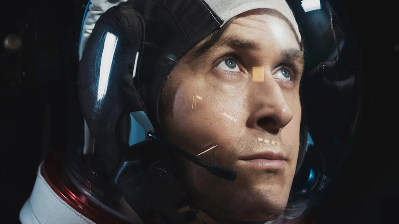 Ryan Gosling sebagai Neil Armstrong dalam setelan luar angkasa melihat ke atas pada pria pertama