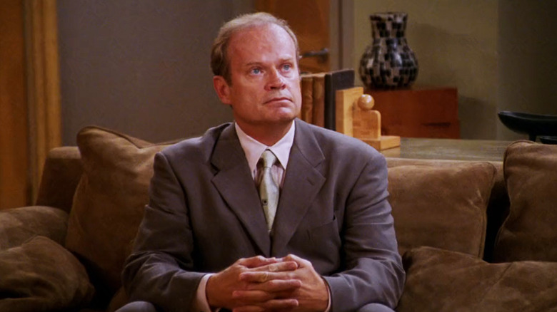 Kelsey Grammer sebagai Frasier Crane duduk di sofa di apartemennya yang melihat lebih frasier