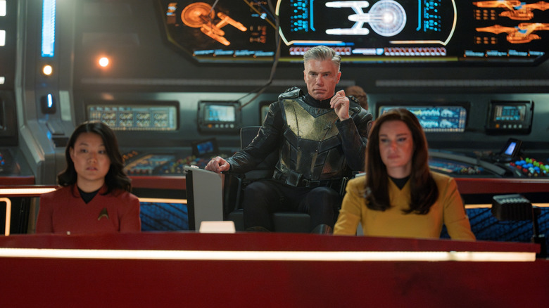 Rong Fu As Mitchell, Anson Mount sebagai Kapten Pike, dan Rebecca Romijn sebagai Una duduk di stasiun mereka di Star Trek: Strange New Worlds