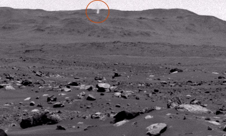 Gambar hitam dan putih dari permukaan Mars dengan twister kecil di cakrawala (dilingkari)