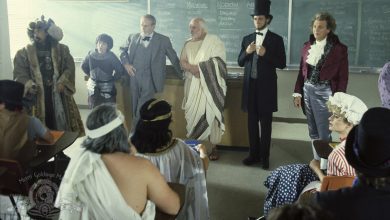 Sekelompok tokoh sejarah berdiri di ruang kelas dalam petualangan Bill dan Ted yang luar biasa