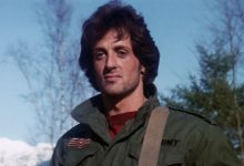 John Rambo Sylvester Stallone berdiri melihat ke kejauhan melawan langit biru dengan darah pertama