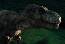 Rexy T-Rex berjalan ke tepi helipad di ujung Jurassic World
