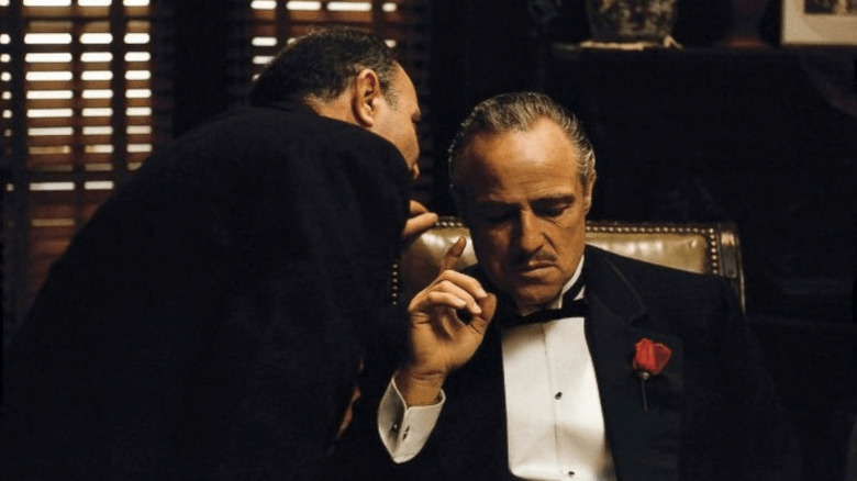 Vito Corleone mendengarkan orang kepercayaannya di The Godfather